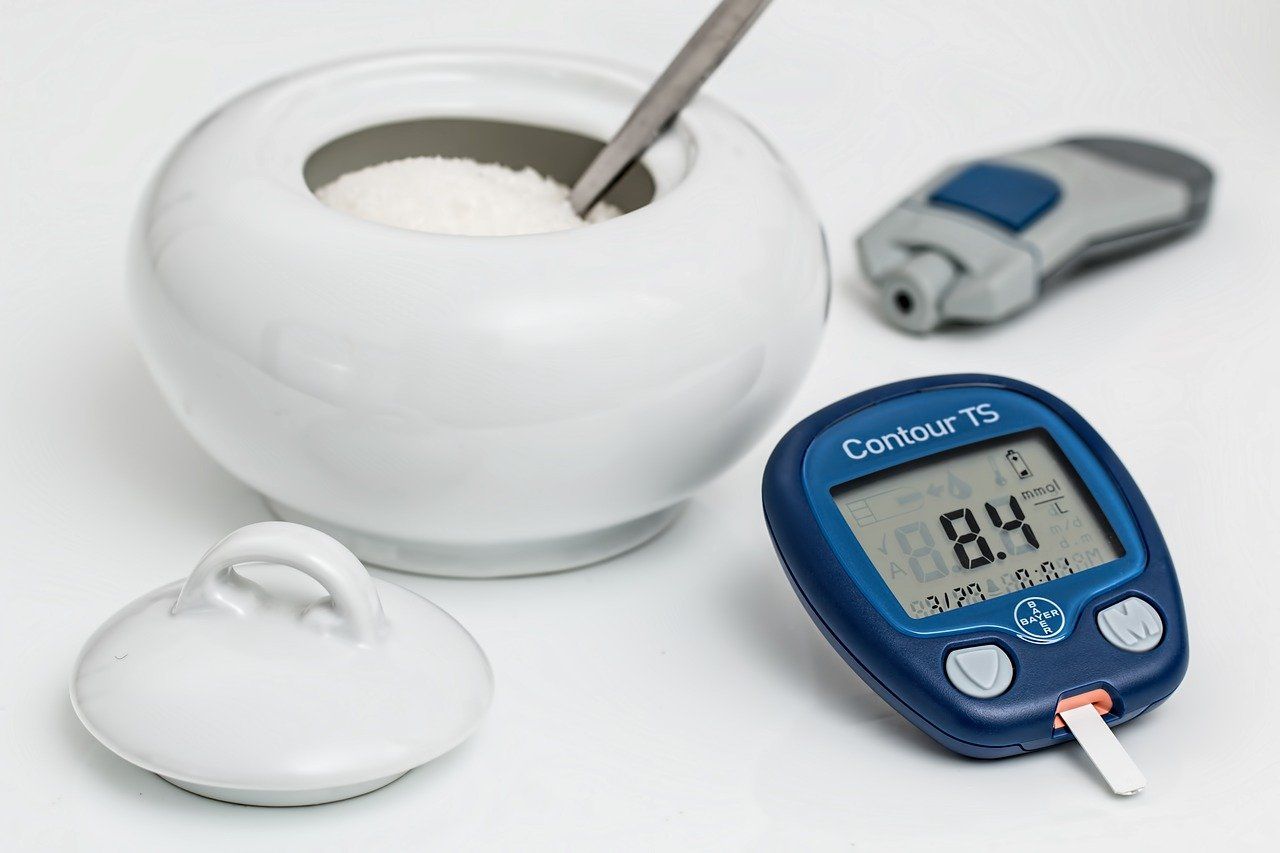 شکر و دستگاه اندازه‌گیری قند خون روی میز است